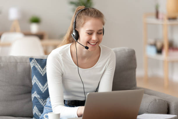 istock Smiling woman wearing headset, using laptop, looking at screen 1143696662