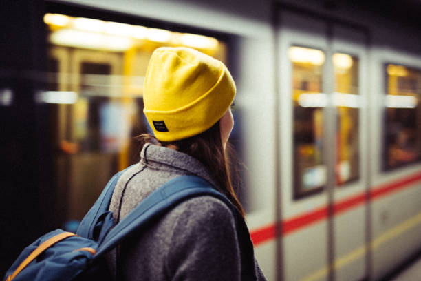 列車が arrrives している間、若い女性は地下鉄駅で待っています。交通と旅行のコンセプト。 - capital city trail ストックフォトと画像