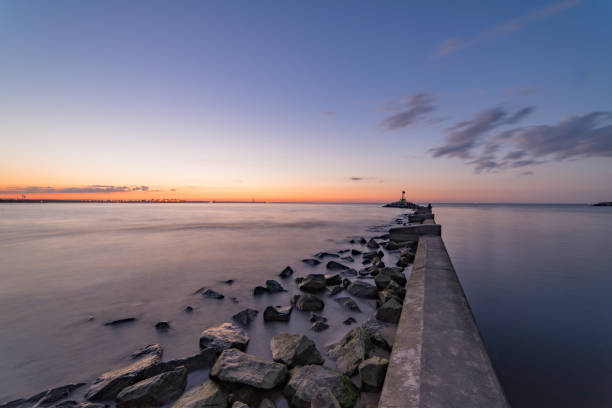 istock Sea sunset with breakwaters. Moody sky 1143698508