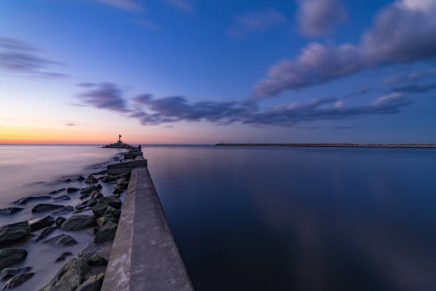 istock Sea sunset with breakwaters. Moody sky 1143698520