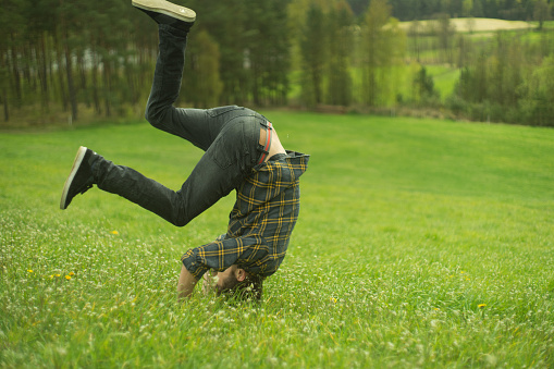 Man making somersault on a grass