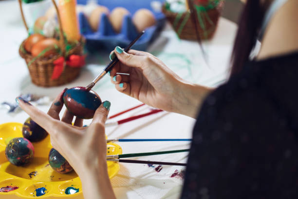 istock Young Female Coloring Easter Eggs for Home Decoration 1143699786