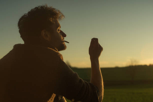 istock Evening cigarette break. Man smoking and admiring sunset 1143699797