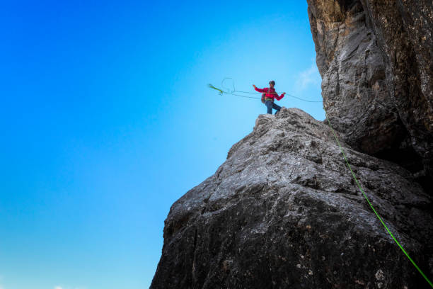 rock climber is throwing his rope from rock ledge - passion mountain range mountain national park imagens e fotografias de stock