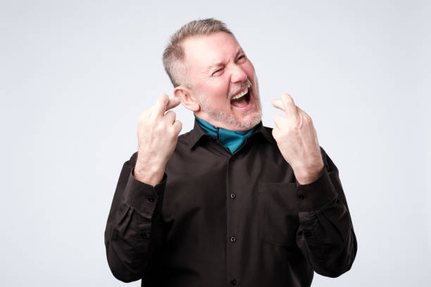 istock Mature man crosses his fingers making a wish 1143702259