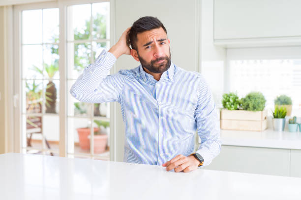 istock Handsome hispanic business man confuse and wonder about question. Uncertain with doubt, thinking with hand on head. Pensive concept. 1143702299