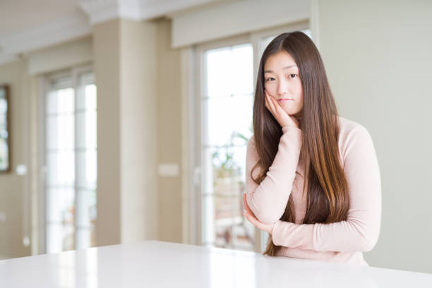 istock Beautiful Asian woman wearing casual sweater on white table thinking looking tired and bored with depression problems with crossed arms. 1143705708