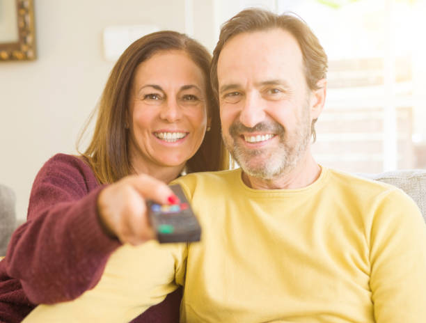 istock Romantic middle age couple watching tv on the sofa at home 1143709454