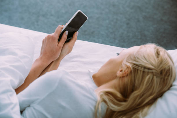 istock lonely woman lying in bed and using smartphone with blank screen 1143709558