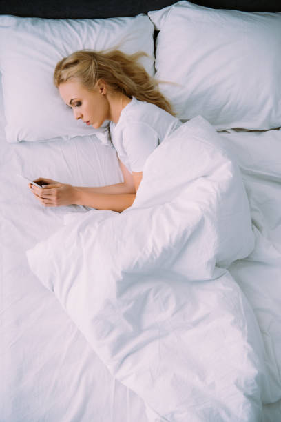 istock sad lonely woman lying in bed and using smartphone 1143709574