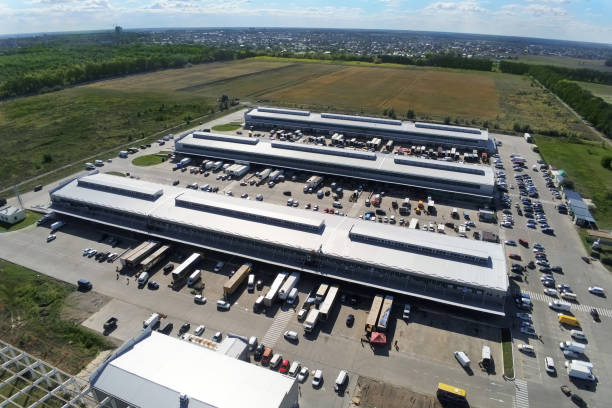 widok z lotu ptaka na grupę dużych nowoczesnych budynków przemysłowych lub fabrycznych w podmiejskiej dzielnicy miasta. logistyczny terminal ładunkowy - distribution warehouse industrial building large building exterior zdjęcia i obrazy z banku zdjęć