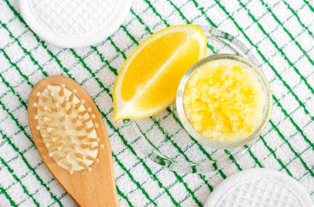 esfoliação caseira (molho de pé ou sal de banho) com sumo de limão e raspas, sal marinho e azeite. escova de cabelo de madeira. diy tratamentos de beleza e receita spa. vista superior, espaço da cópia - lemon juice horizontal composition fruit - fotografias e filmes do acervo