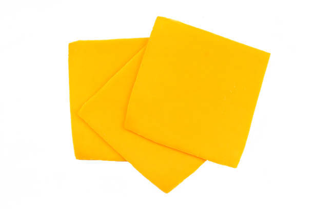 sliced cheddar cheese sliced cheddar cheese on a white background cheddar cheese stock pictures, royalty-free photos & images