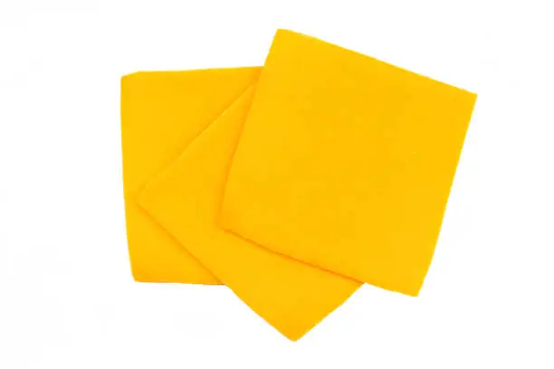 sliced cheddar cheese on a white background