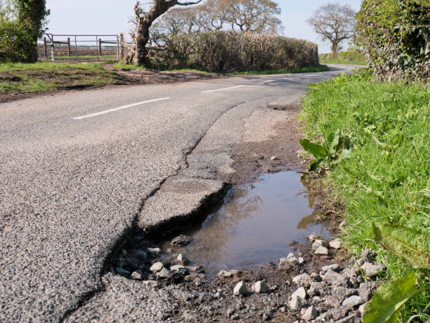 istock Unrepaired pothole - surface damage to tarmac on a rural road 1143713960