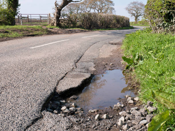 dano de superfície de buraco não reparado ao asfalto em uma estrada rural - pot hole - fotografias e filmes do acervo