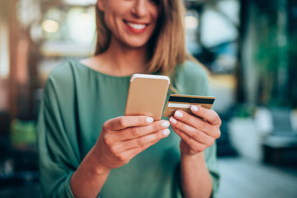 istock Girl holding credit card and texting 1143714064
