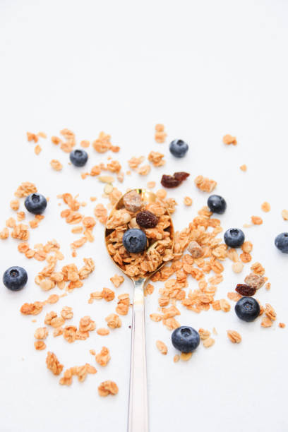istock Crispy muesli and blueberry on a spoon Breakfast cereal isolated on white background, selective focus, top view 1143714345