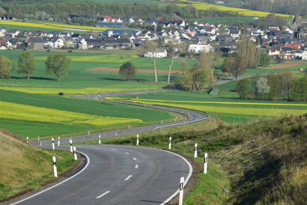 istock curvy road through spring hills into village 1143717729