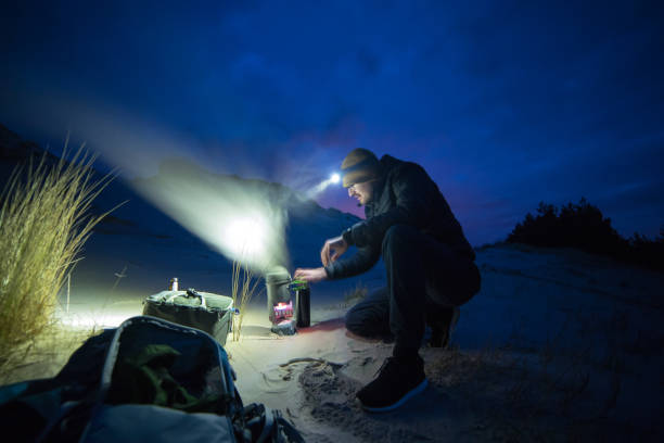 istock Beach camp at night. Man preparing meal 1143718320