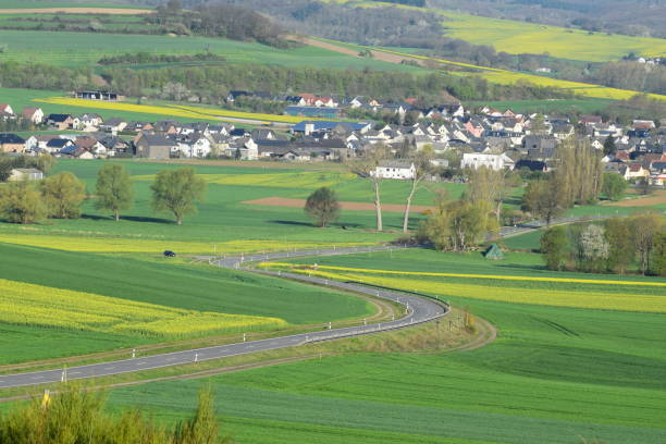 istock curvy road through spring hills into village 1143718379