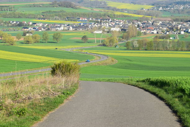 istock curvy road through spring hills into village 1143719121