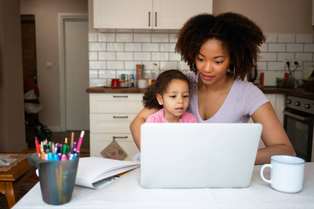 istock Mother and daughter using laptop at home 1143719359