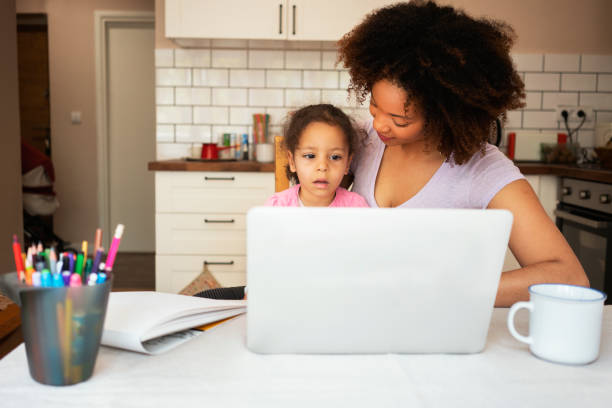 istock Mother and daughter using laptop at home 1143719360