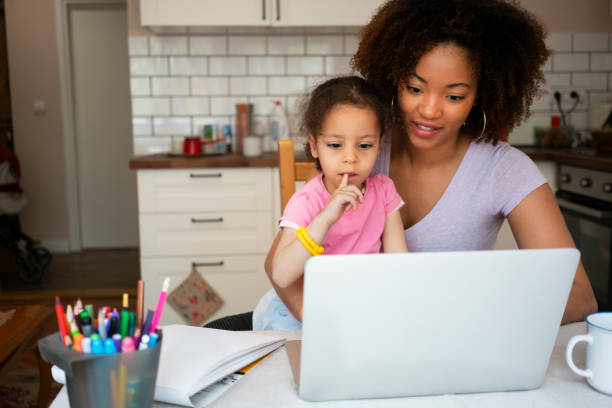 istock Mother and daughter using laptop at home 1143719454