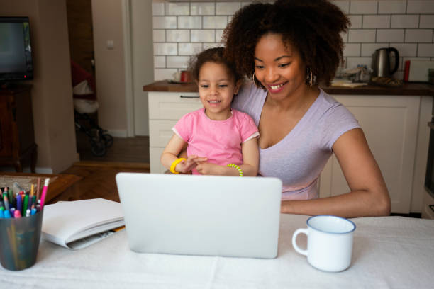 istock Mother and daughter using laptop at home 1143720318