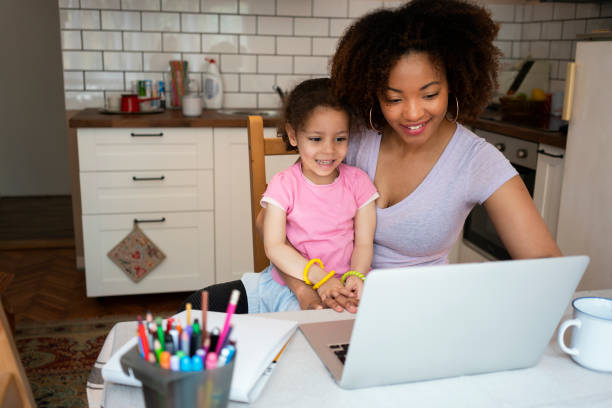istock Mother and daughter using laptop at home 1143720323