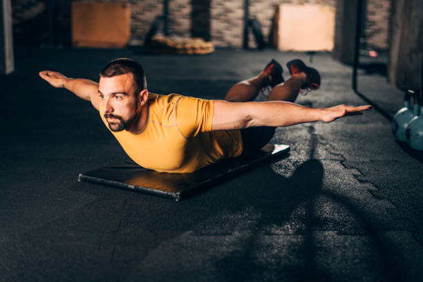 istock Muscular sportsman doing a swimmers exercise routine on his belly in a gym 1143720963