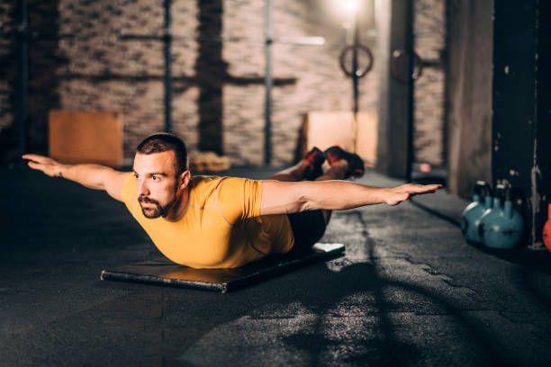 istock Young athletic man doing a swimmers workout routine on his belly in a gym 1143721846