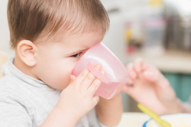istock child in the kitchen drinking from a cup of water 1143723211
