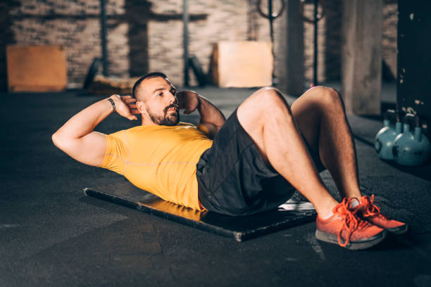 istock Strong athletic man doing a sit ups exercise in a gym 1143723867