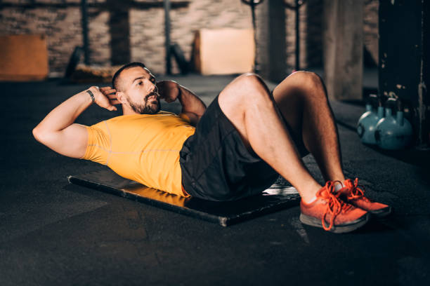 istock Strong athletic man doing a sit ups exercise in a gym gym 1143725099