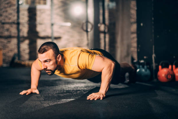 istock Young muscular sportsman doing push ups exercise in a gym 1143725767