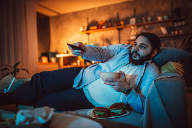 istock Fat man eating fast food 1143728671