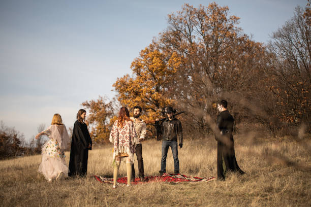 Group of young, weird people dancing on meadow on beautiful autumn day