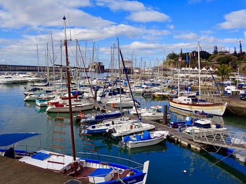 Funchal, Madeira, Portugal--April 4, 2019  Sailboats and pleasure boats dominate the marina area in Funchal on the Portugese Island of Madeira. The Prinsendam, a Holland America Cruise ship, can be seen in the distance..