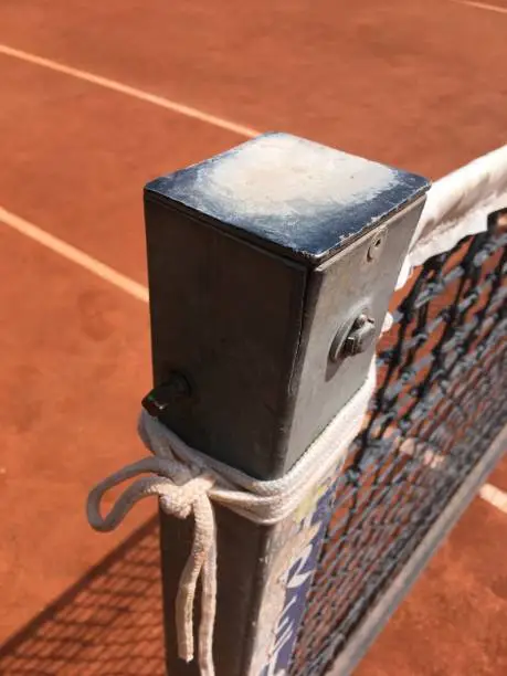 Close up image. Top of a Netpost on a Tenniscourt