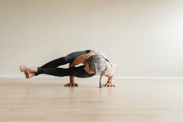 mistrz jogi kobieta robi osiem kąt pozy, astavakrasana. - posture women side view yoga zdjęcia i obrazy z banku zdjęć