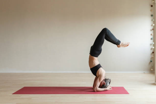 Master Yoga woman doing Headstand, Sirsasana.