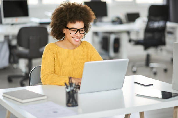 istock Smiling businesswoman using laptop in modern office. 1143744374
