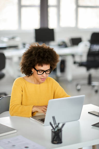 istock Smiling businesswoman using laptop in modern office. 1143744808