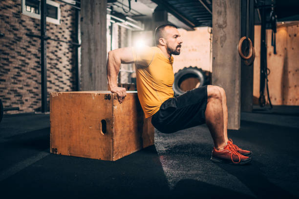 istock Active young male sportsperson doing dips exercise on a gym crate in a gym 1143744955
