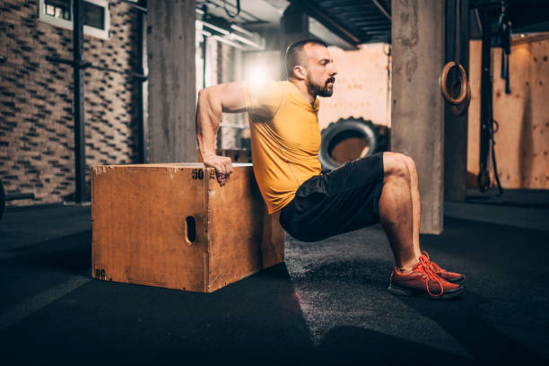 istock Buff male athlete doing dips workout on a gym box in a gym 1143747956