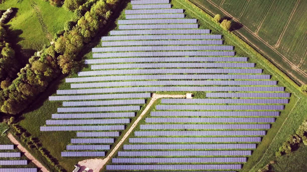 top aerial view of solar energy panels in solar energy farm, photovoltaic power station - service engineer fotos imagens e fotografias de stock