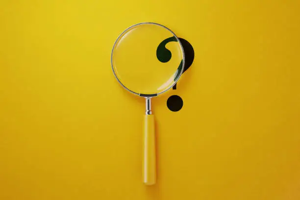 Photo of Magnifier And Question Mark On Yellow Background