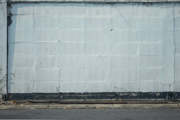 istock Old block concrete wall with pole and asphalt road 1143750871